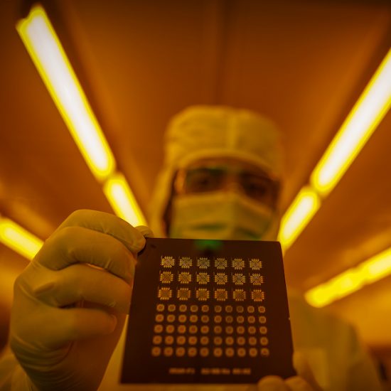 a research scientist holds a nanotechnology device in UIC's Nanotechnology Core Facility